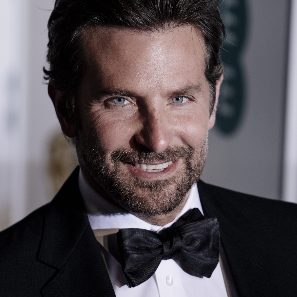 Улыбающийся актер Брэдли Купер в костюме