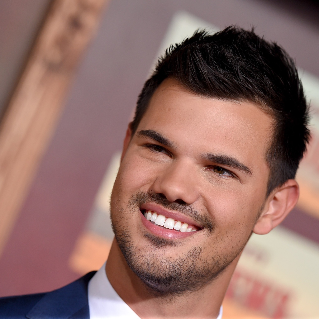 Улыбающийся молодой мужчина, актер Тэйлор Лотнер