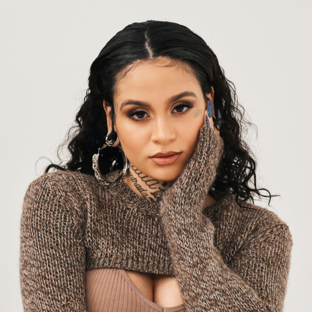 Американская певица Кейлани в свитере на сером фоне