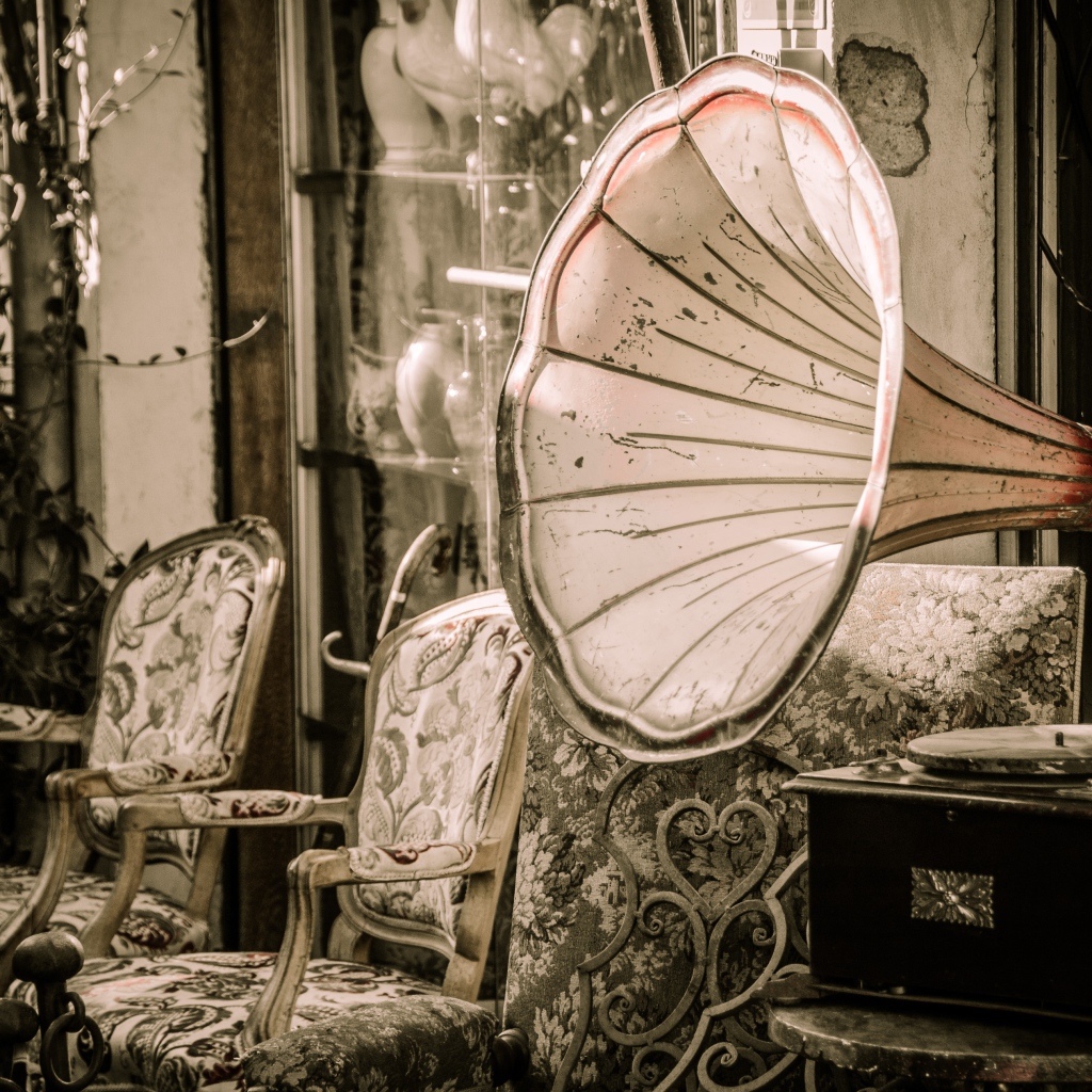 Большой старый граммофон в комнате со стульями