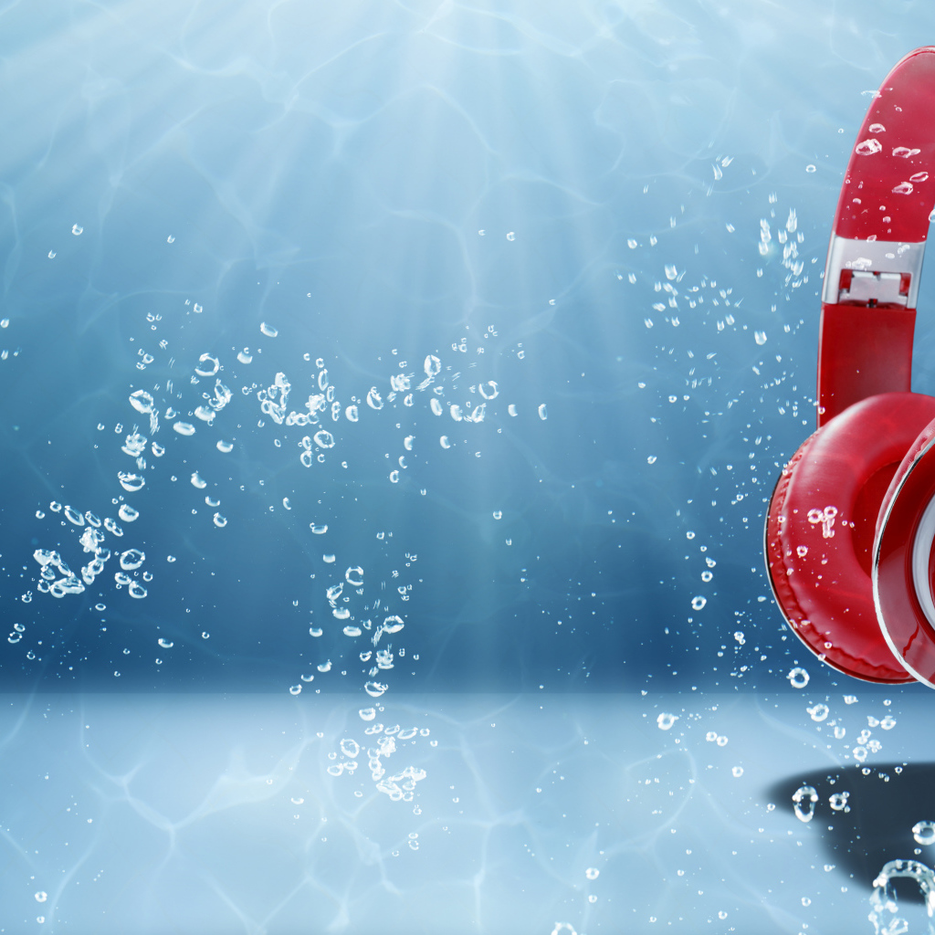 Большие красные наушники под водой на голубом фоне