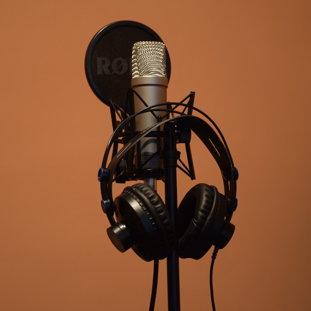 Конденсаторный микрофон с наушниками на коричневом фоне