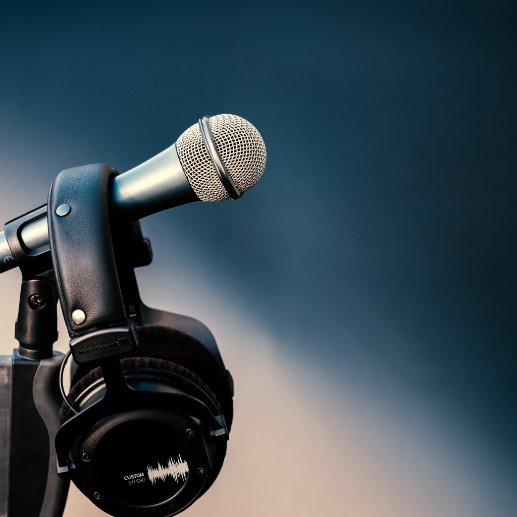 Микрофон с черными наушниками на стойке 