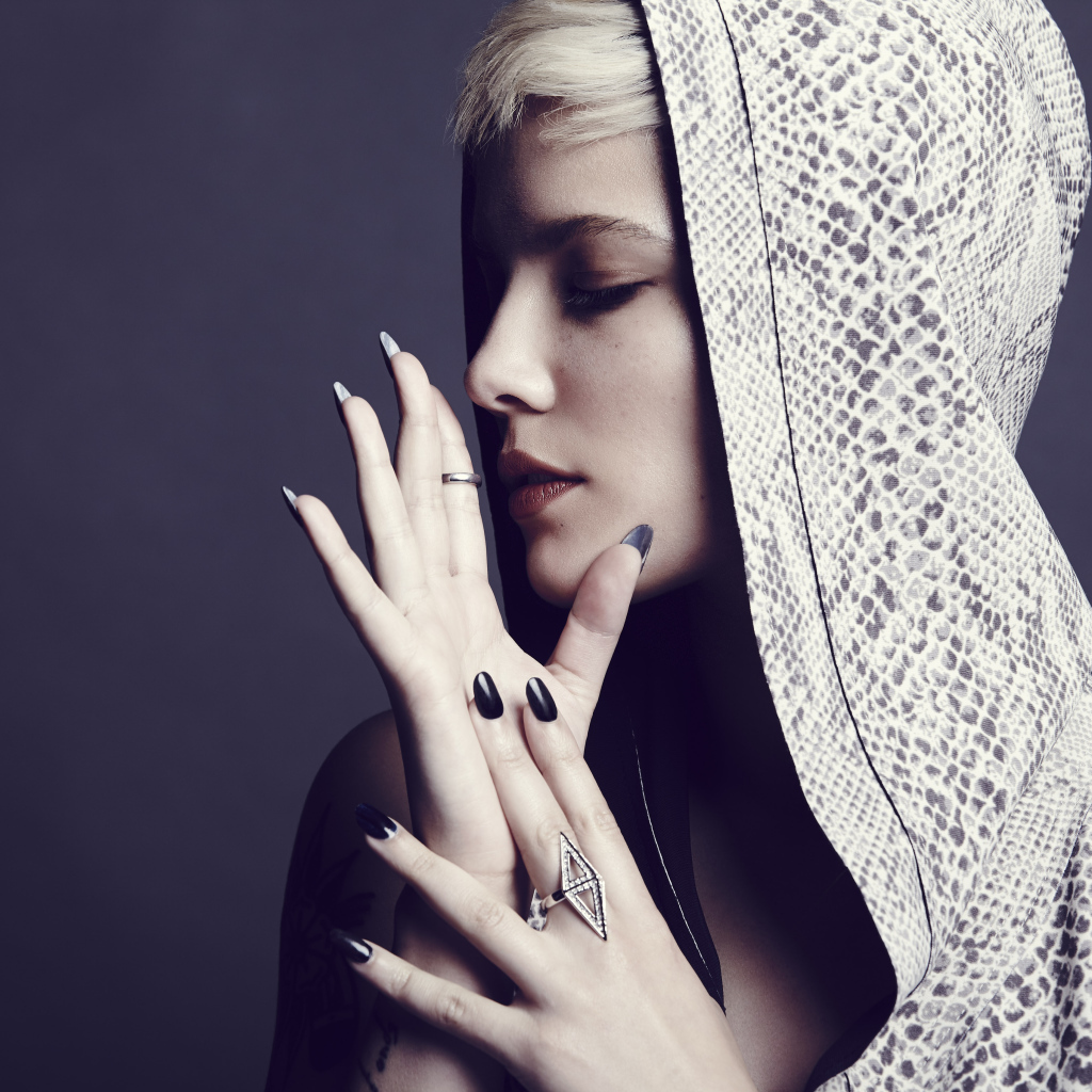 Певица Холзи в капюшоне на сером фоне