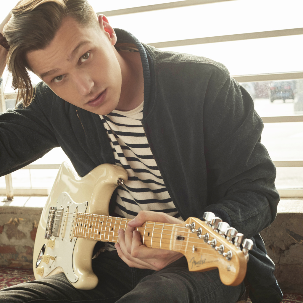 Певец Патрик Дрони с гитарой в руках