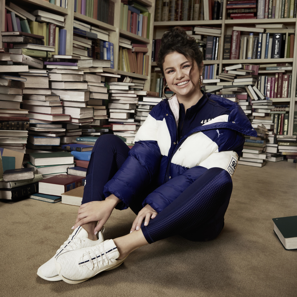 Улыбающаяся певица Селена Гомез в библиотеке 