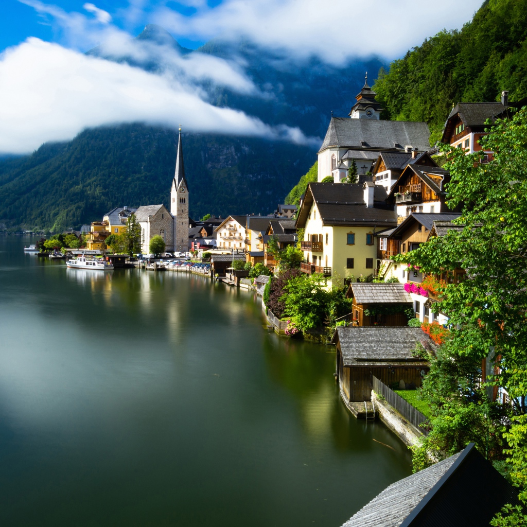Beautiful houses on the shore of a calm lake at the foot of the mountains