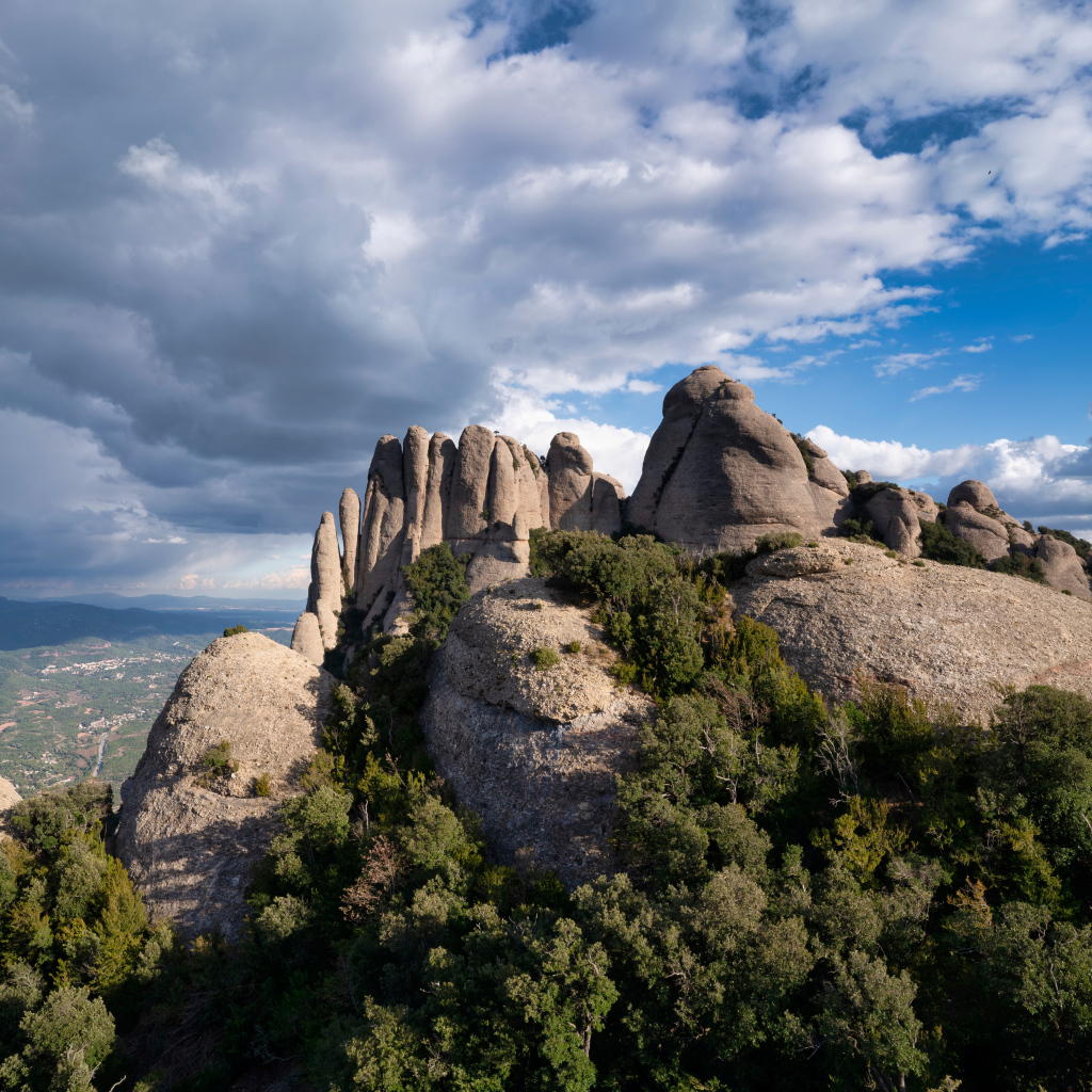 Каменные глыбы под голубым небом с грозовыми облаками 