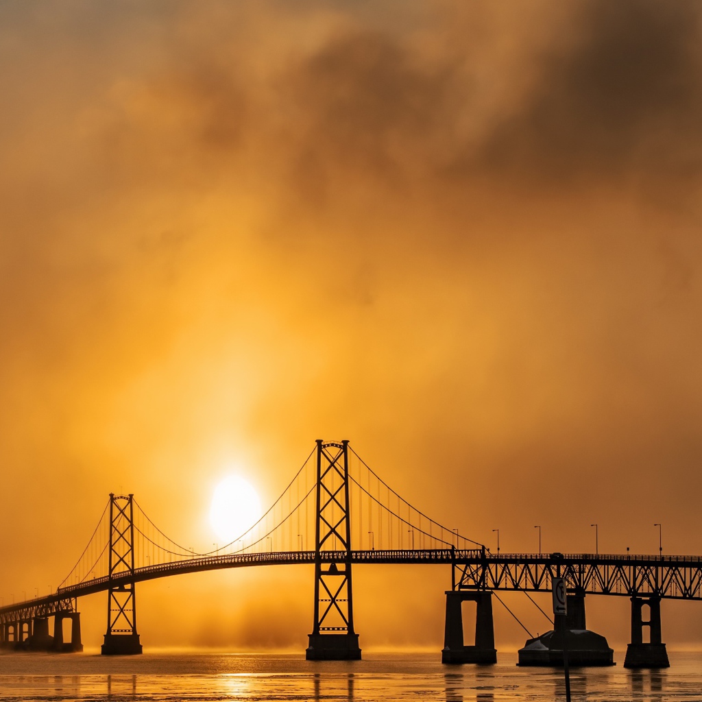 Мост через реку в тумане на восходе солнца