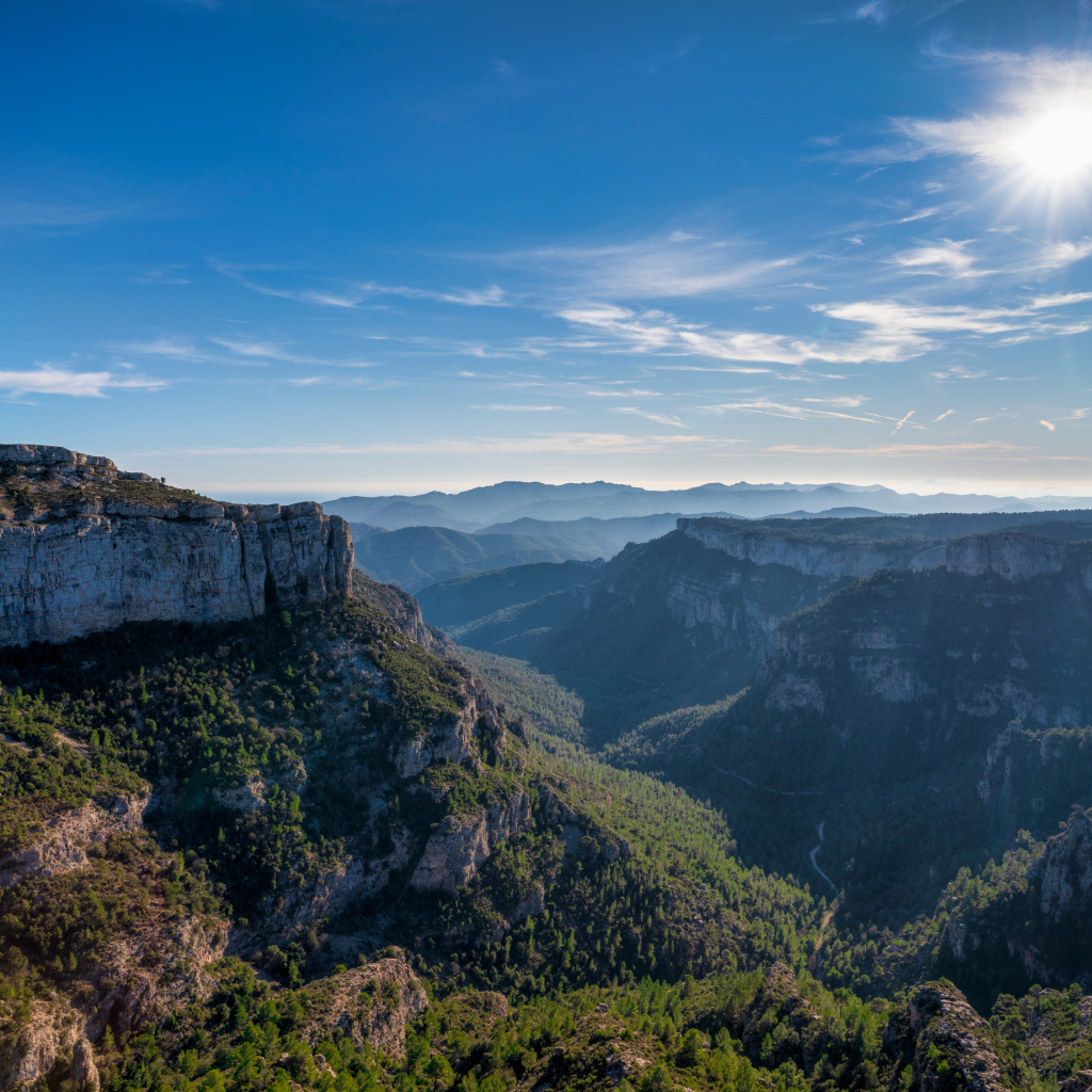 Яркое солнце в голубом небе над высокими горами 