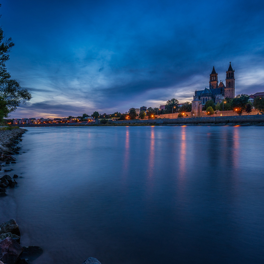 Замок у реки на фоне неба в сумерках 