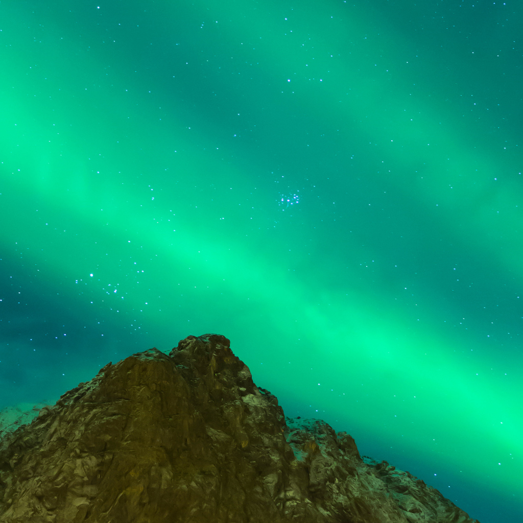 Green aurora borealis over a cliff in the sky
