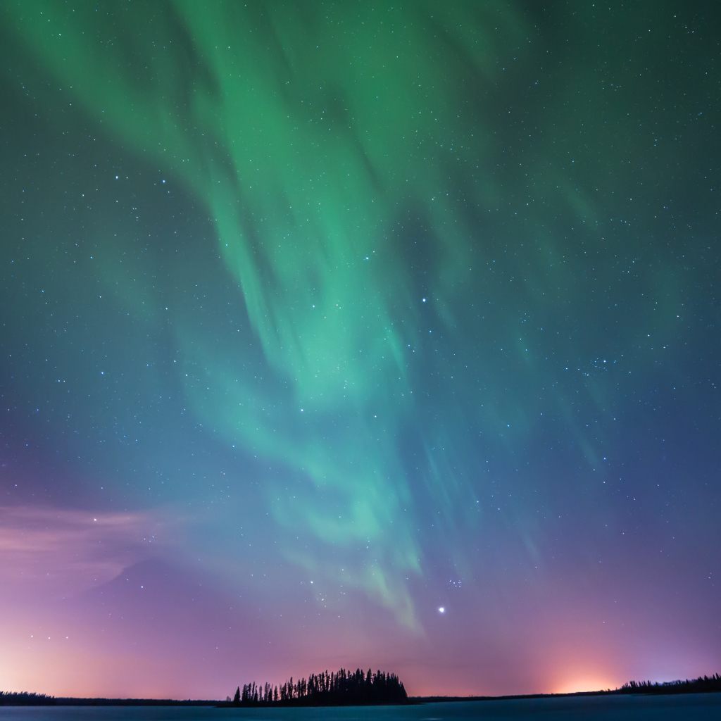 Зеленое северное сияние над заснеженным полем