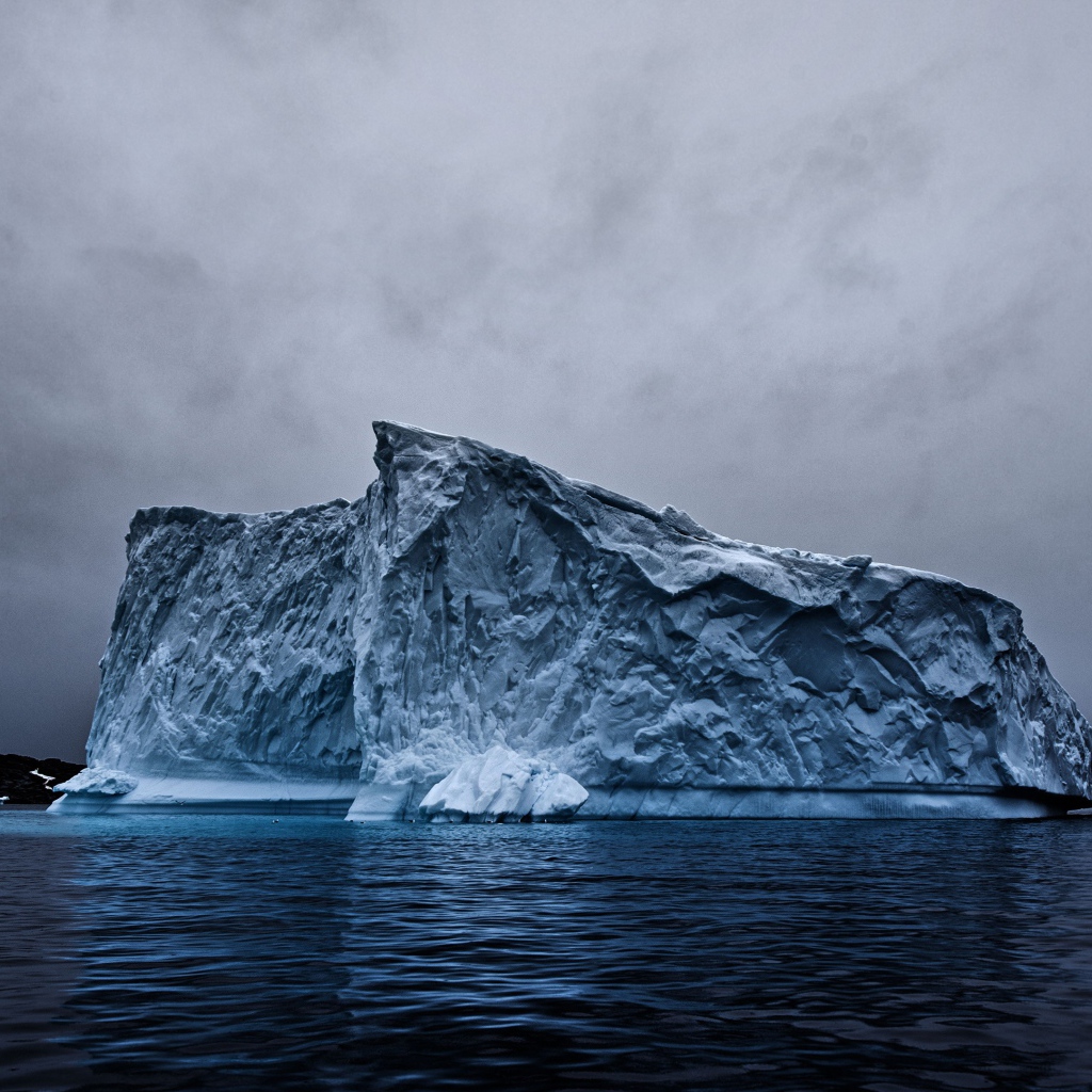 Большой айсберг в океане под пасмурным небом