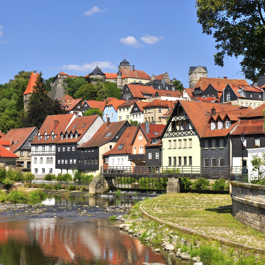 Много домов у пруда на фоне голубого неба