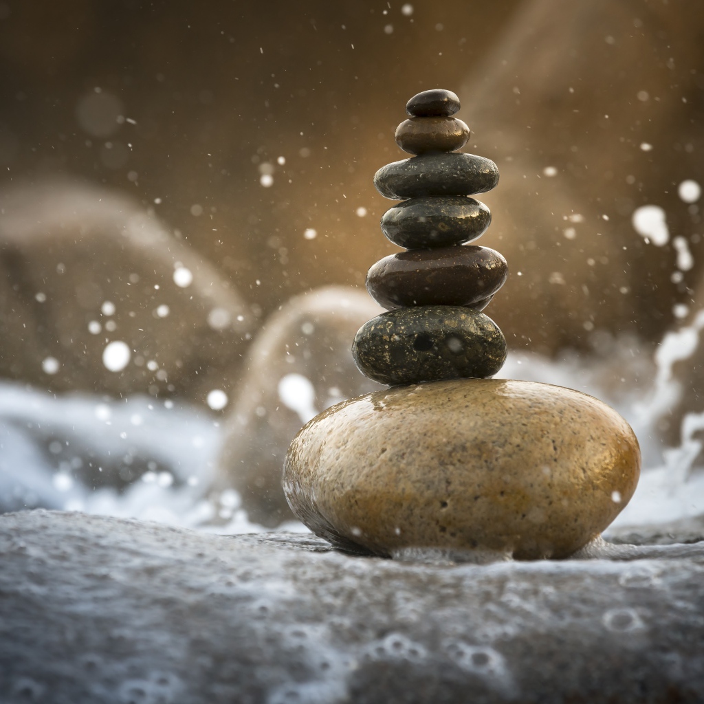 Гладкие мокрые камни в белой морской пене 