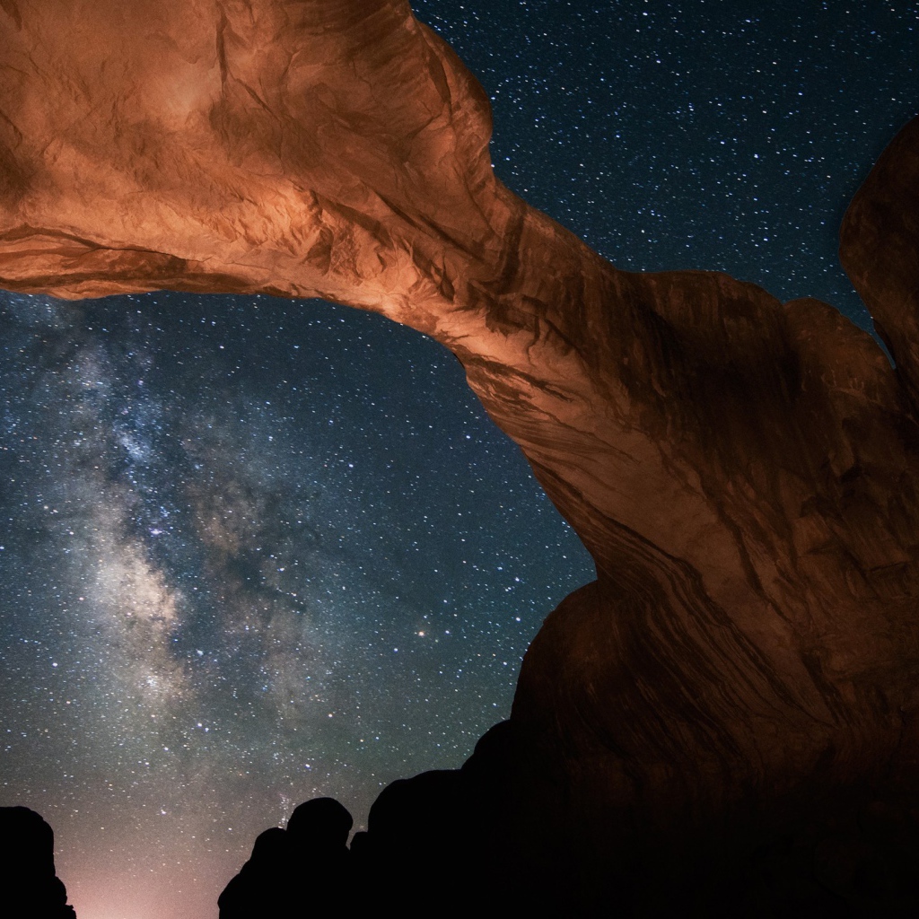 Каменная природная арка под звездным небом ночью 