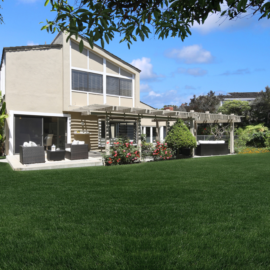 Двухэтажный дом с зеленым газоном 