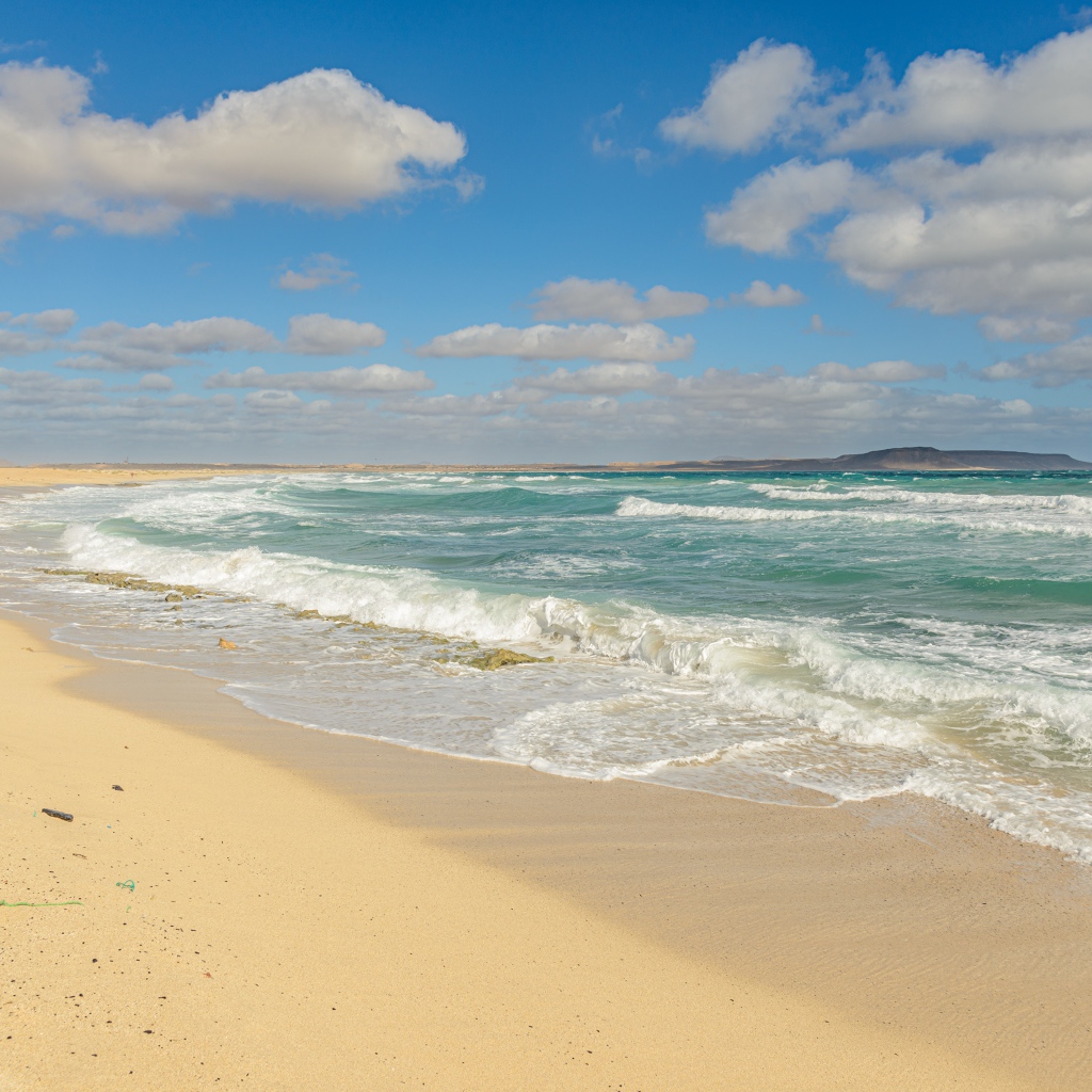 Бушующие морские волны на желтом горячем песке 
