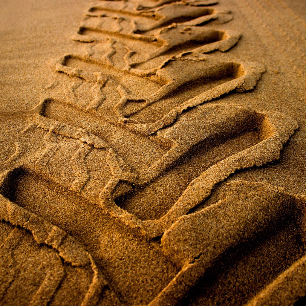 След от колеса трактора на мокром песке