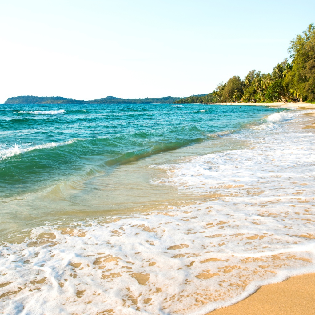 Белая пена на желтом песке тропического пляжа 