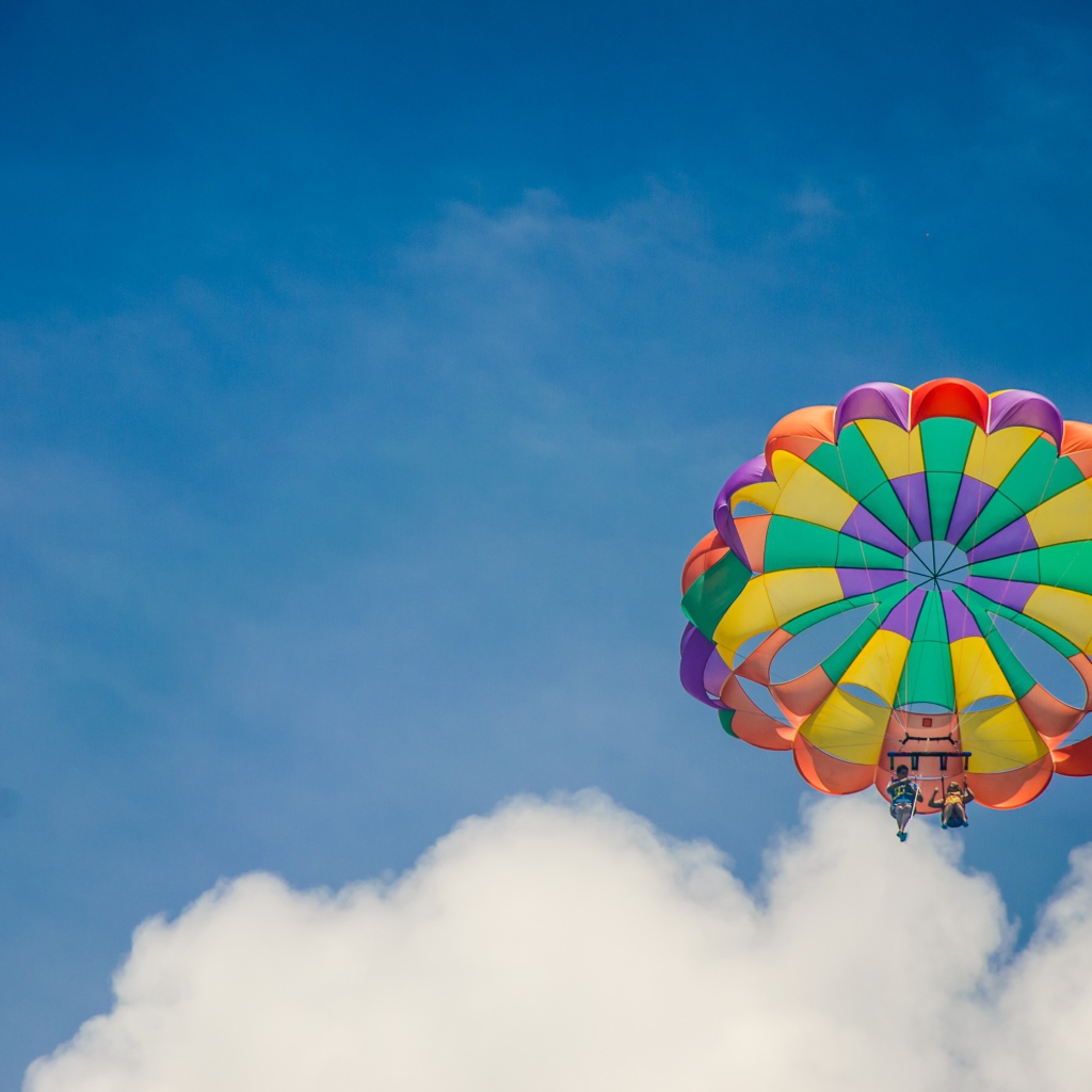 Парашют в голубом небе с белыми облаками