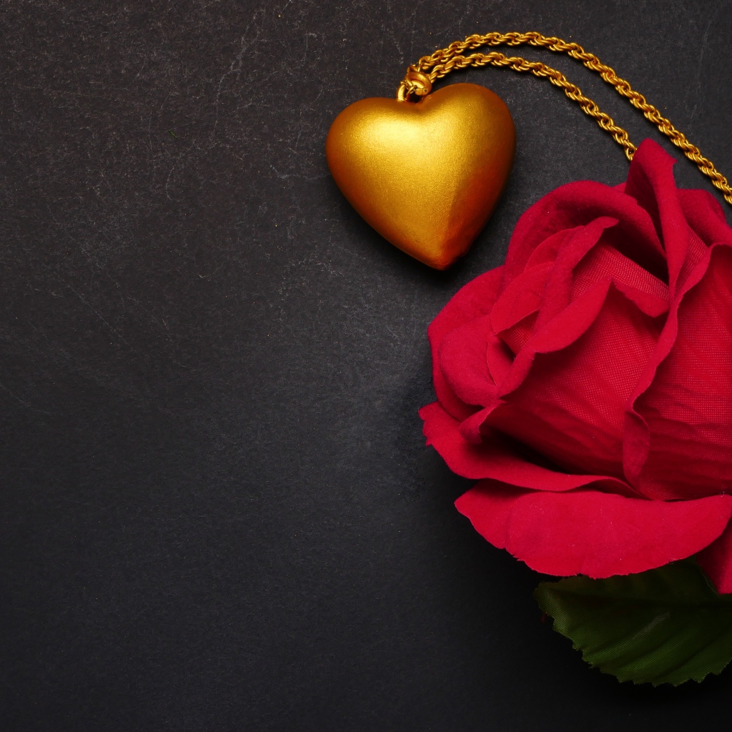 Искусственная красная роза с кулоном на сером фоне