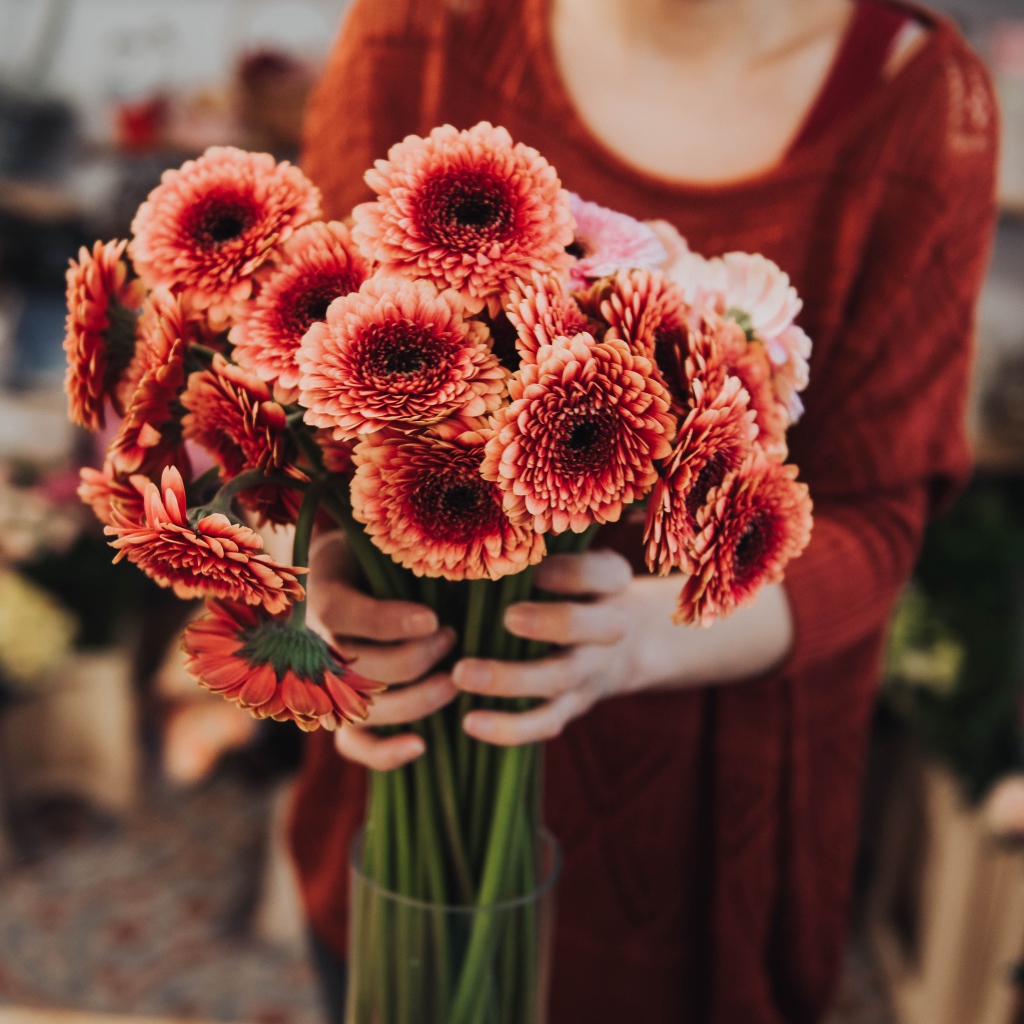 Красивый букет оранжевых гербер в руках у женщины 