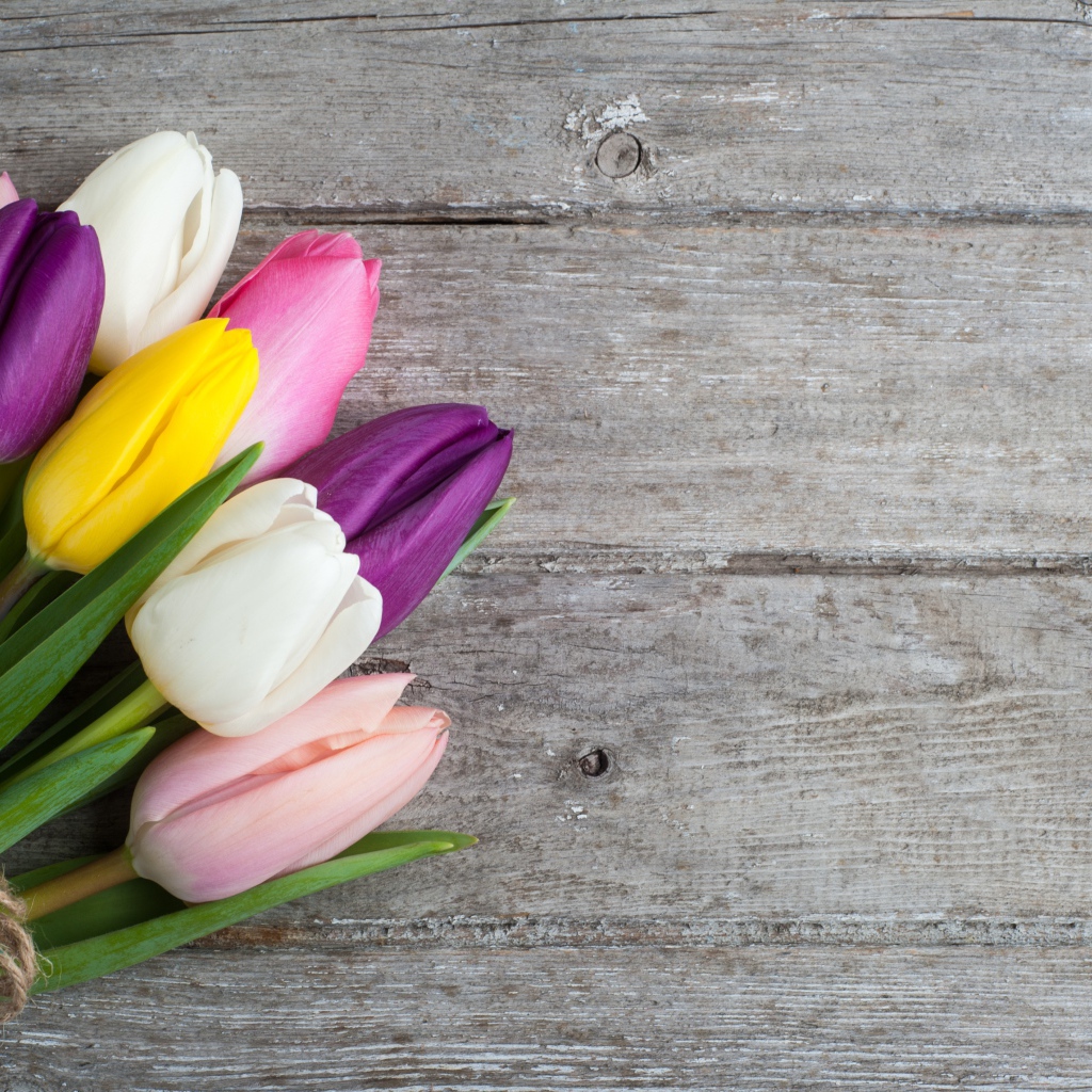 Букет разноцветных тюльпанов на деревянном столе