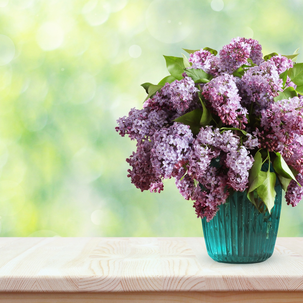 Букет ароматной сирени в вазе на столе