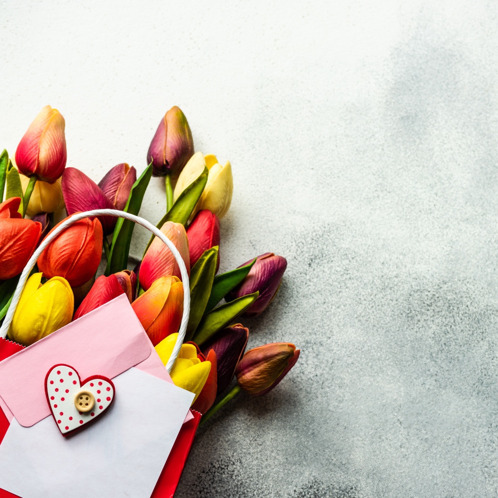Букет разноцветных тюльпанов с письмом на сером фоне