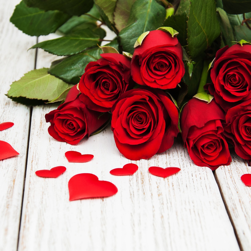 Букет красных роз с зелеными листьями на белом фоне с сердечками 