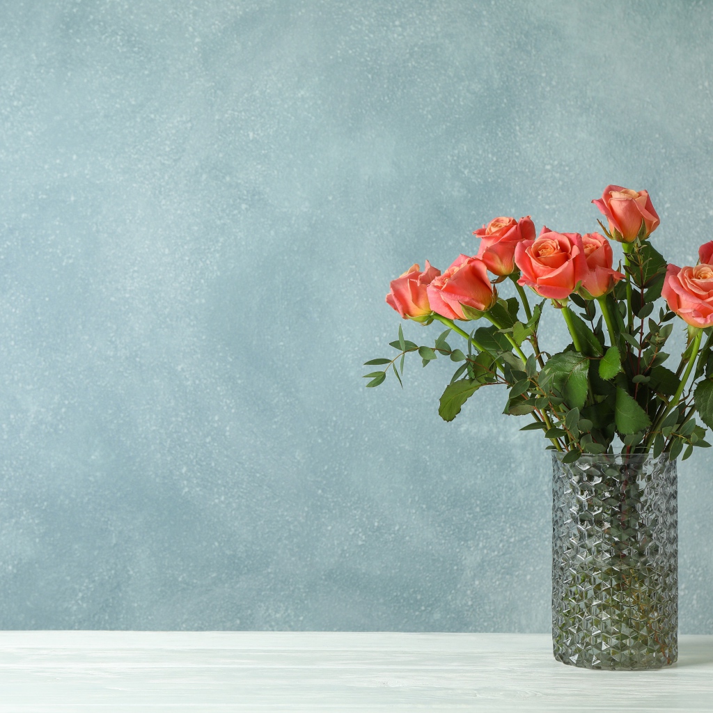 Bouquet of roses in a glass vase on a gray background