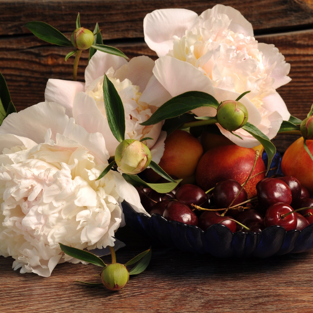 Букет белых пионов на столе с нектарином и черешней