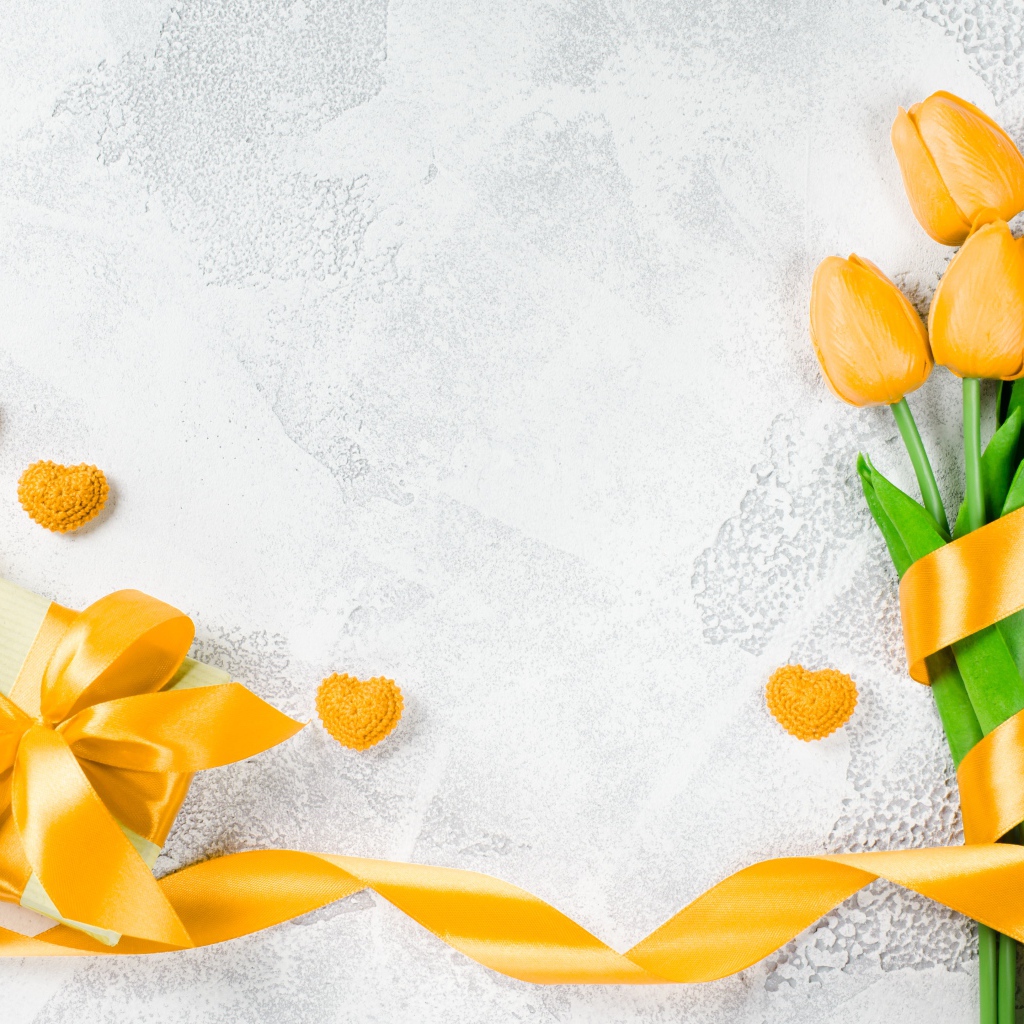 Букет желтых тюльпанов с лентой и подарком на сером фоне