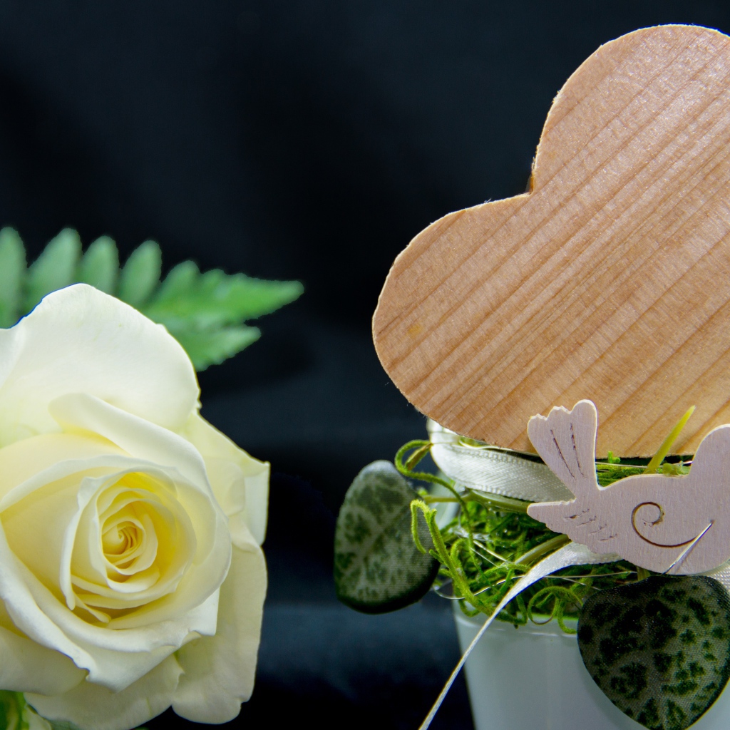 Деревянное сердце и белая роза на столе 