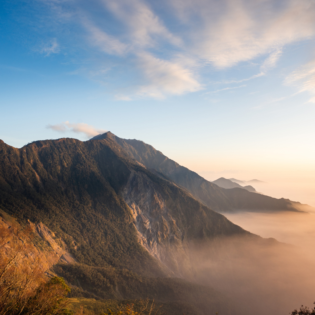 Красивый вид на покрытые туманом горы под голубым небом