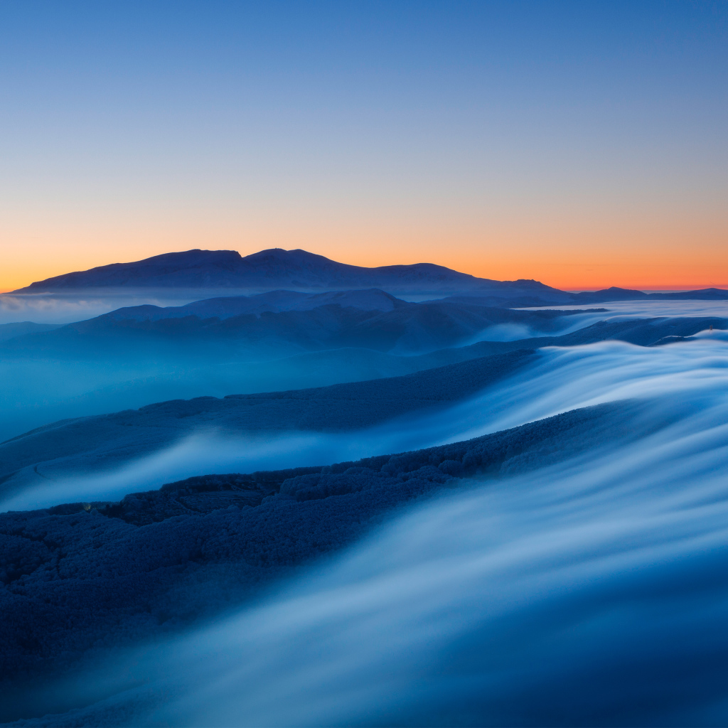 Туман покрывает высокие горы на рассвете 