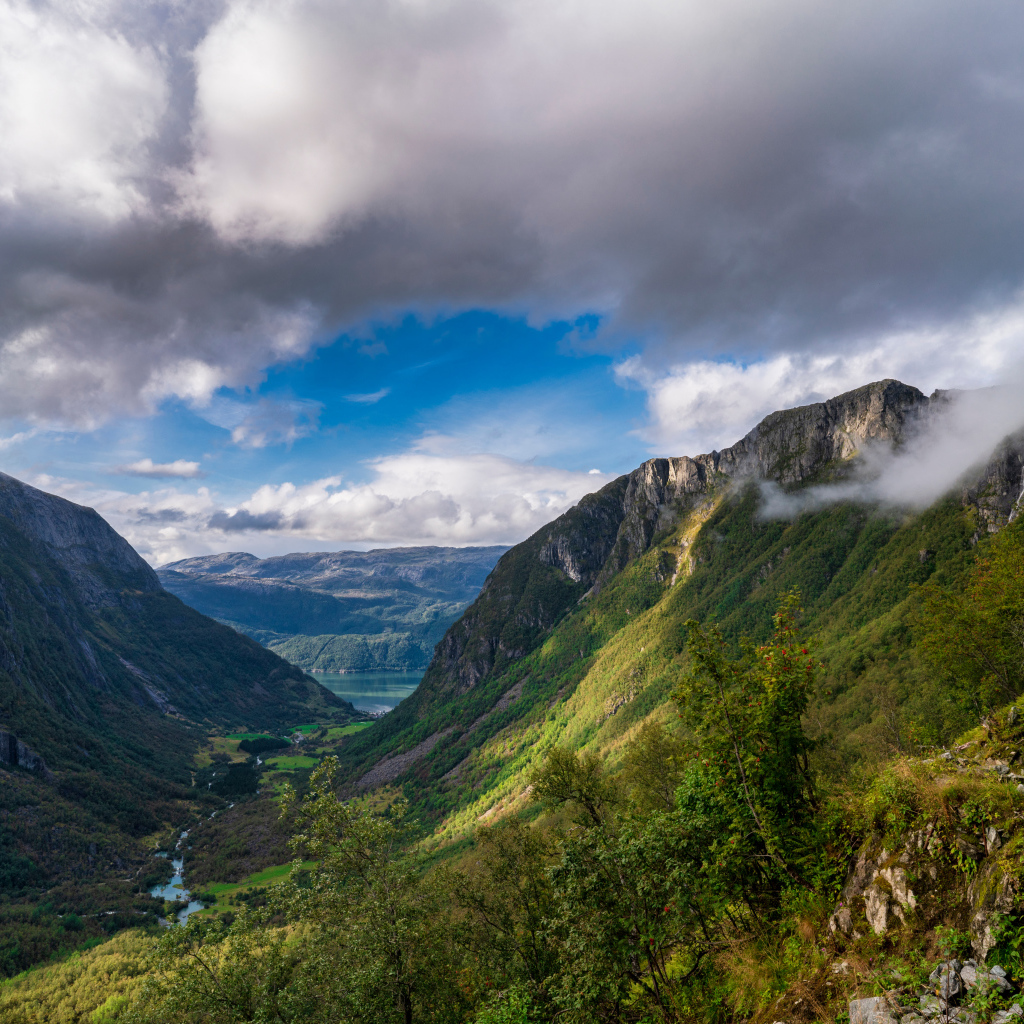 Покрытые зеленой растительностью горы под белыми облаками, Норвегия