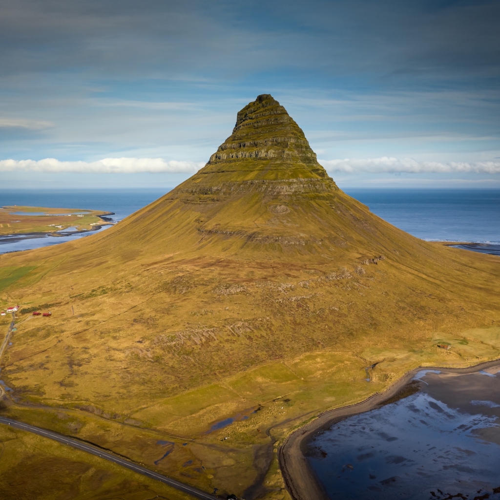 Зеленая гора Киркьюфетль под голубым небом, Исландия