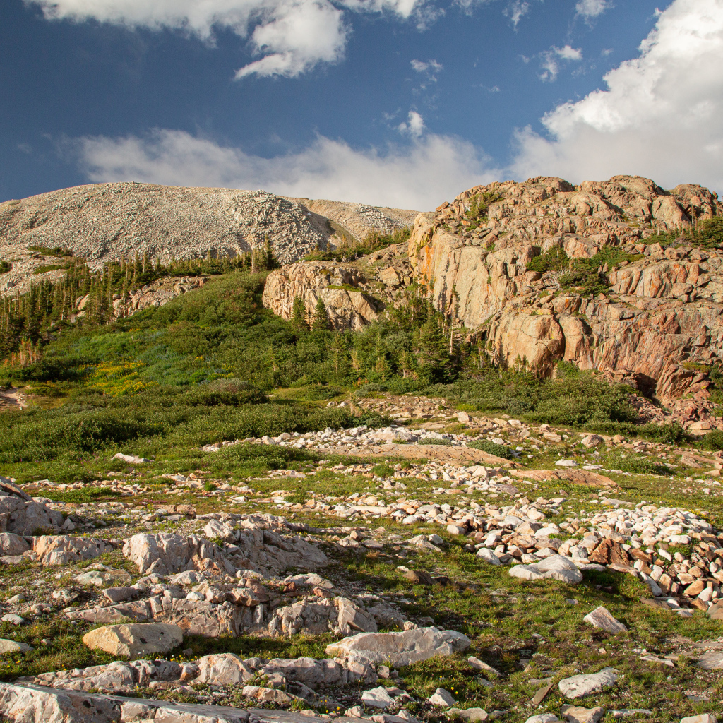 Высокие каменные горы под  голубым небом с белыми облаками