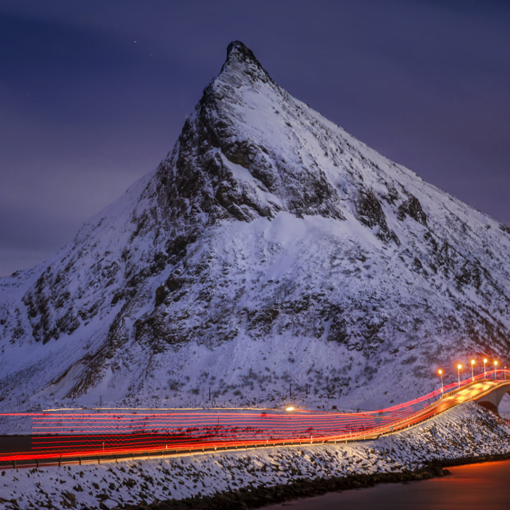 Ночная дорога у заснеженных гор 