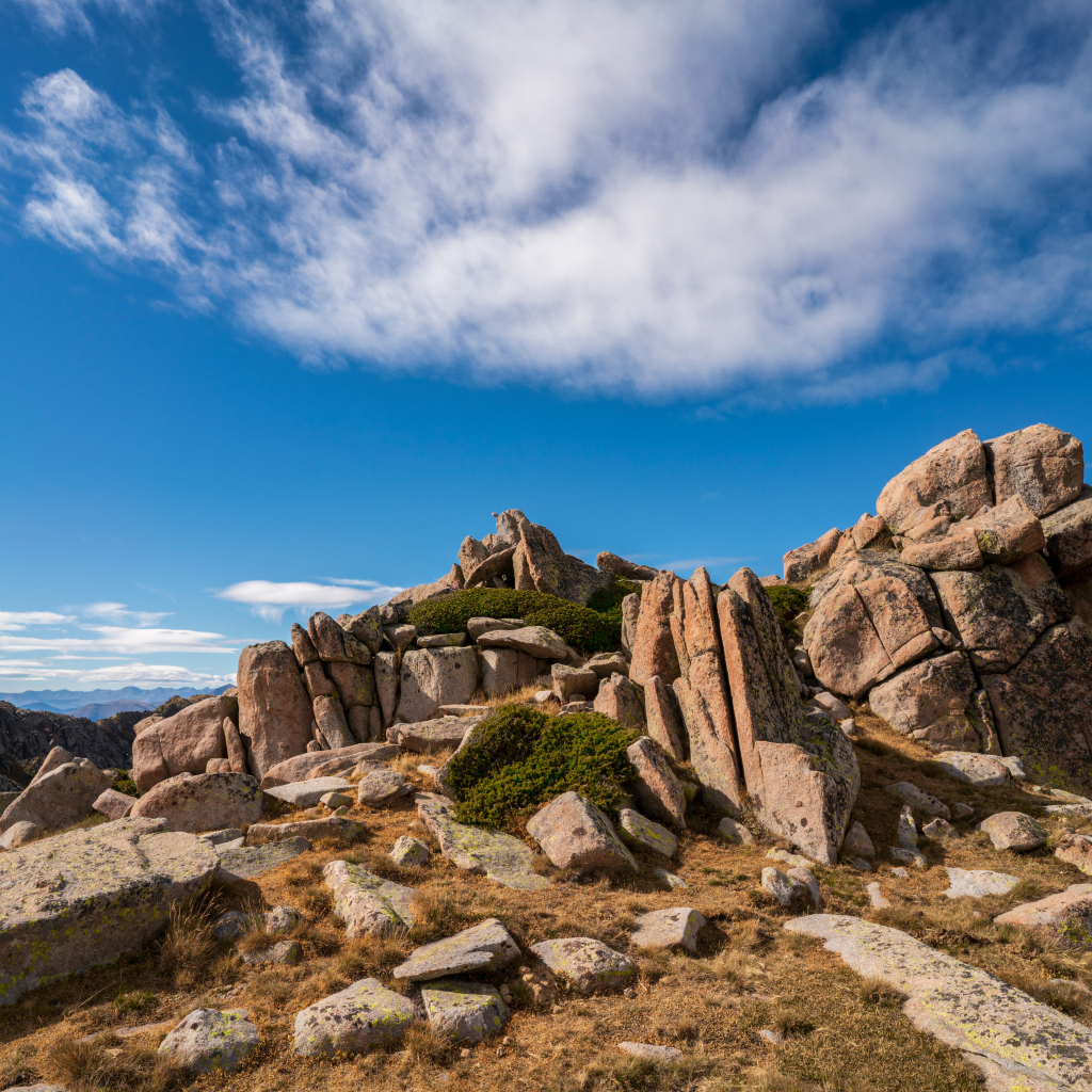 Каменные горы под голубым небом с белыми облаками 