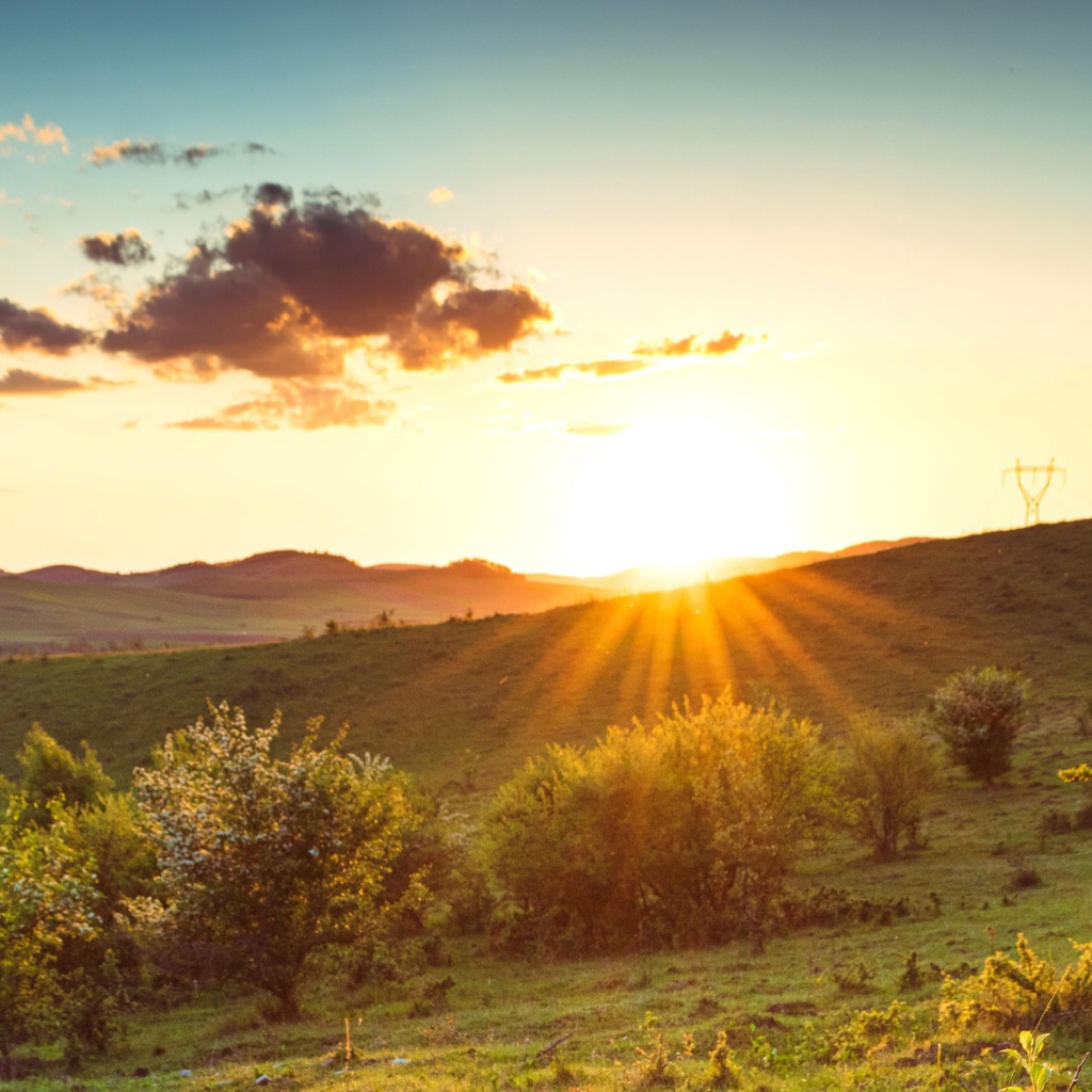 Яркое летнее солнце встает из-за гор 