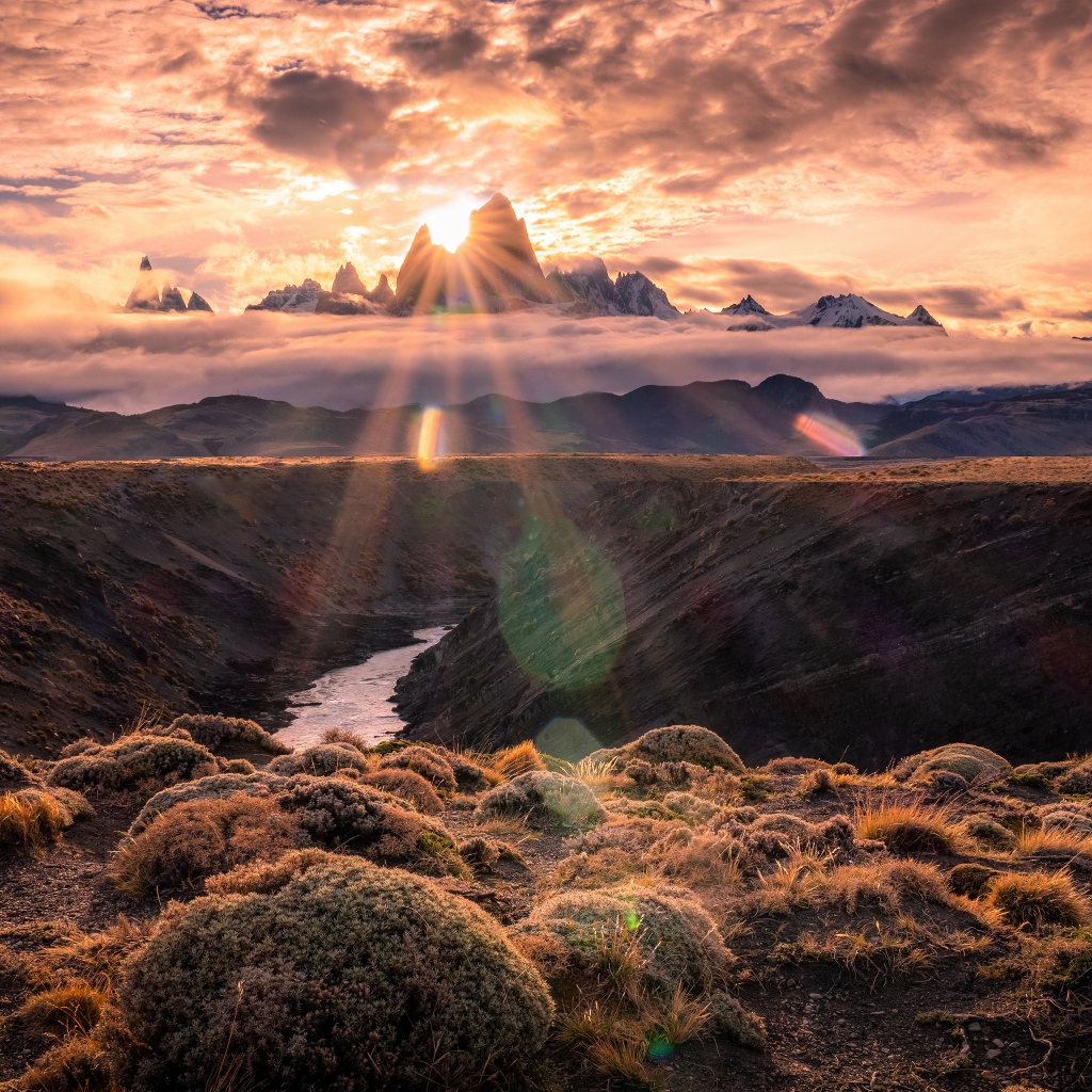 Лучи яркого солнца пробиваются сквозь вершину горы на рассвете 