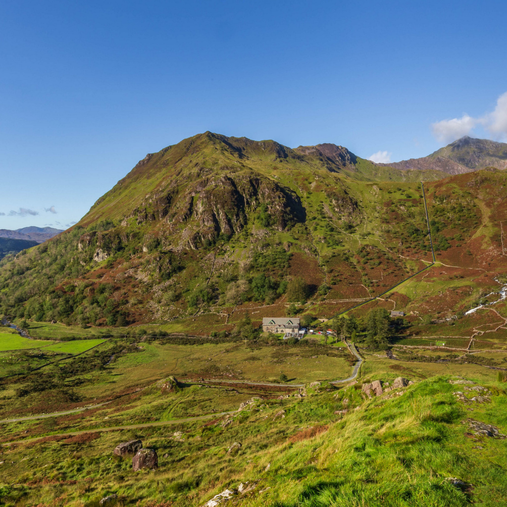 Вид на покрытую зеленью гору под голубым небом
