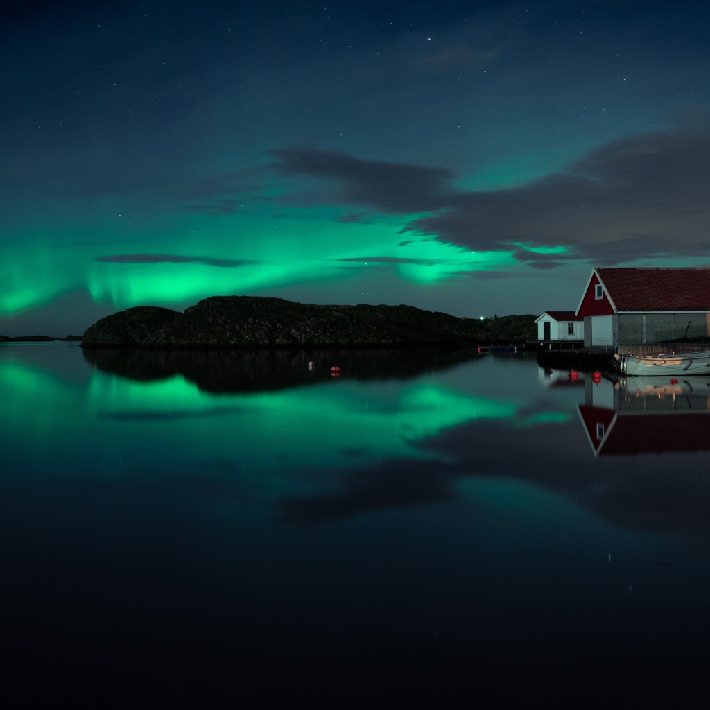 Дома на берегу озера на фоне полярного сияния 