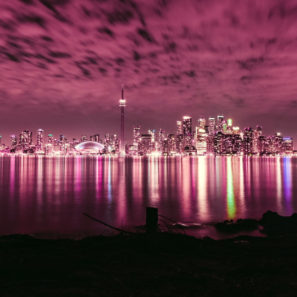 Ночной город под голубым небом отражается в воде 