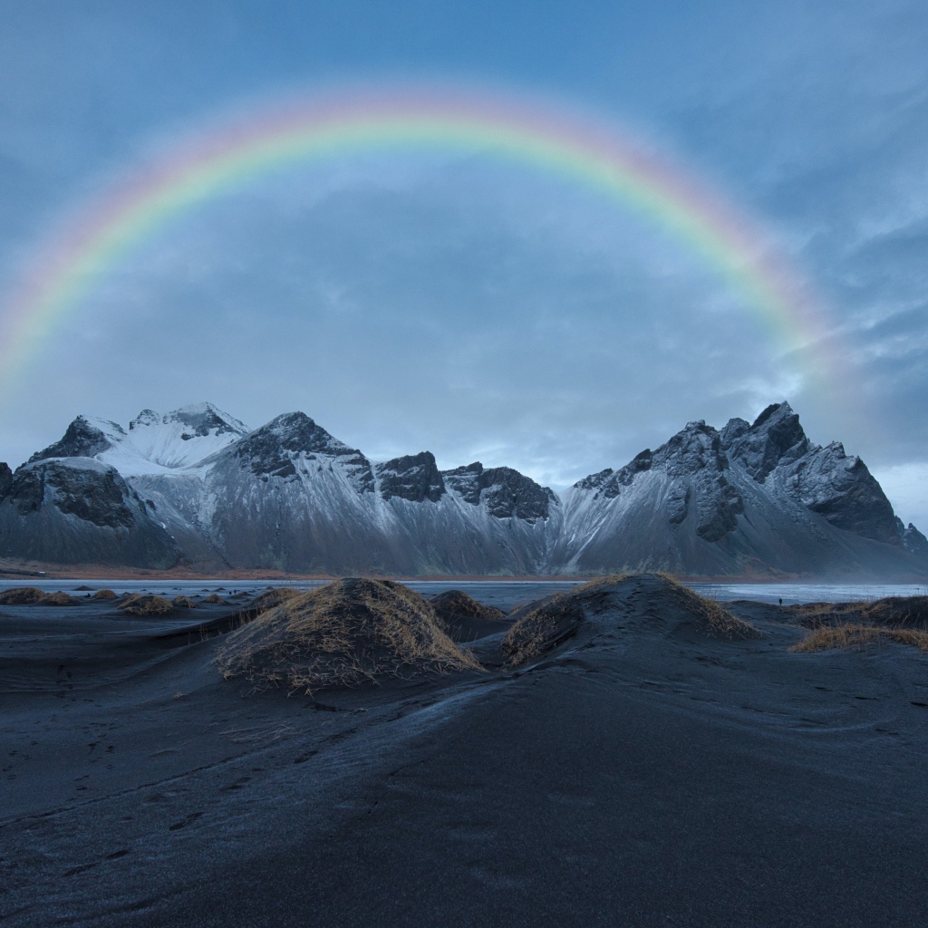 Радуга в небе над высокими горами
