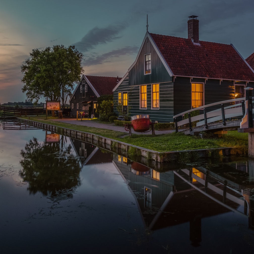 Маленькие дома у пруда вечером 